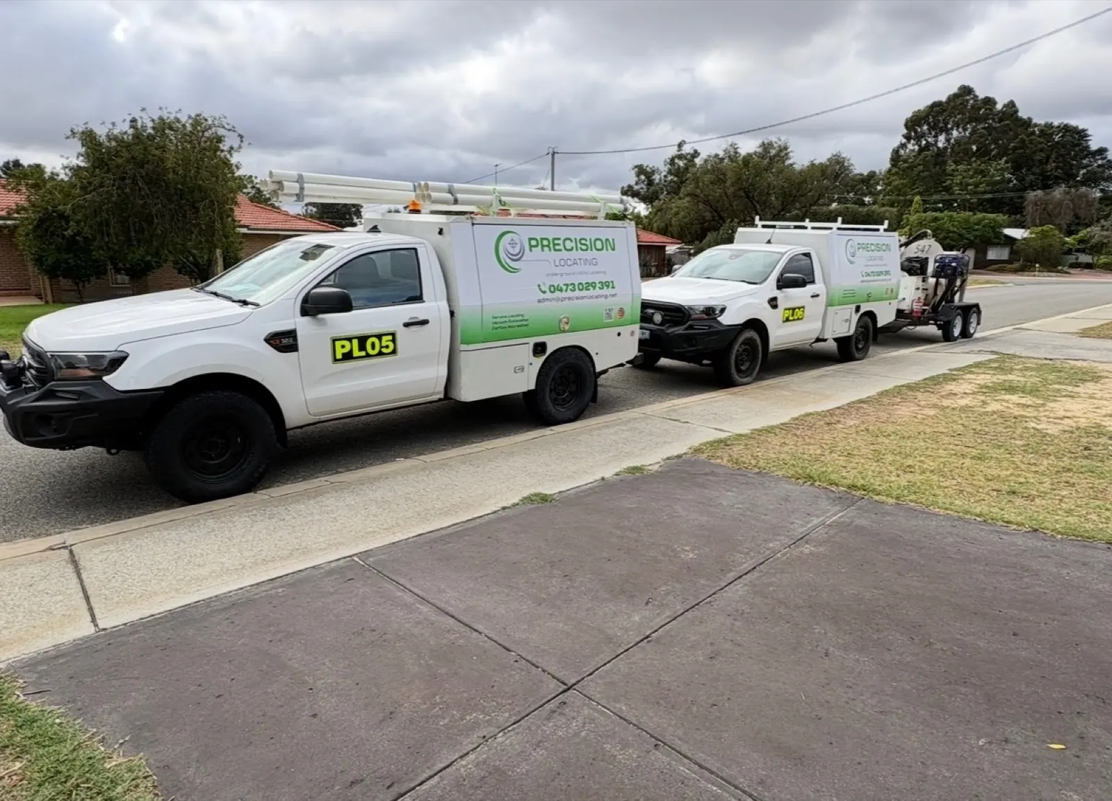Two branded Precision Locating service vehicles ready for field work